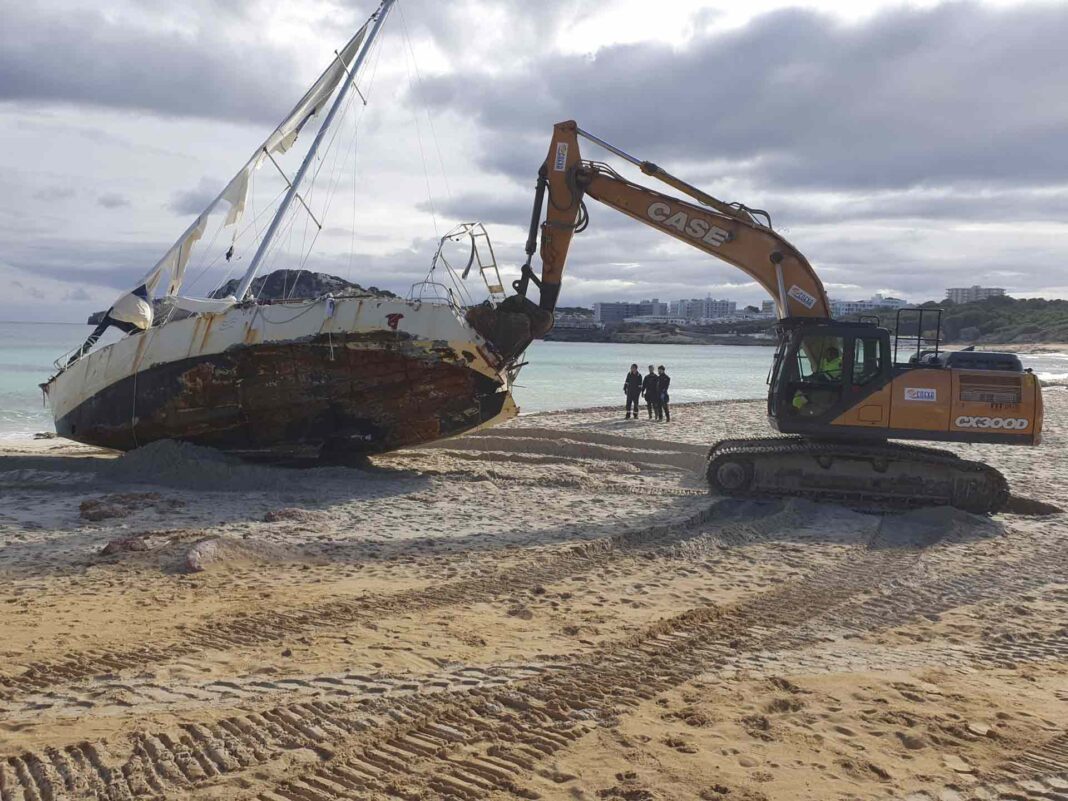 Barco hundido en Cala Agulla retirado por una grúa